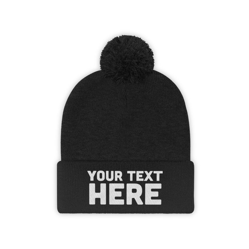 a black beanie with a pom - pom on it