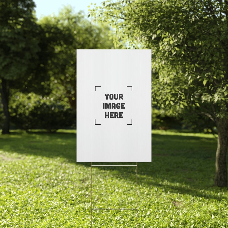 a white sign sitting on top of a lush green field