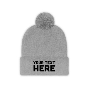 a grey beanie with a white pom - pom