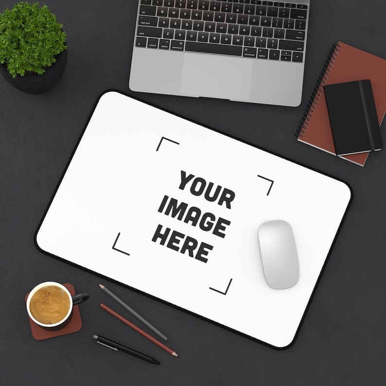 a mouse pad sitting on top of a desk next to a laptop