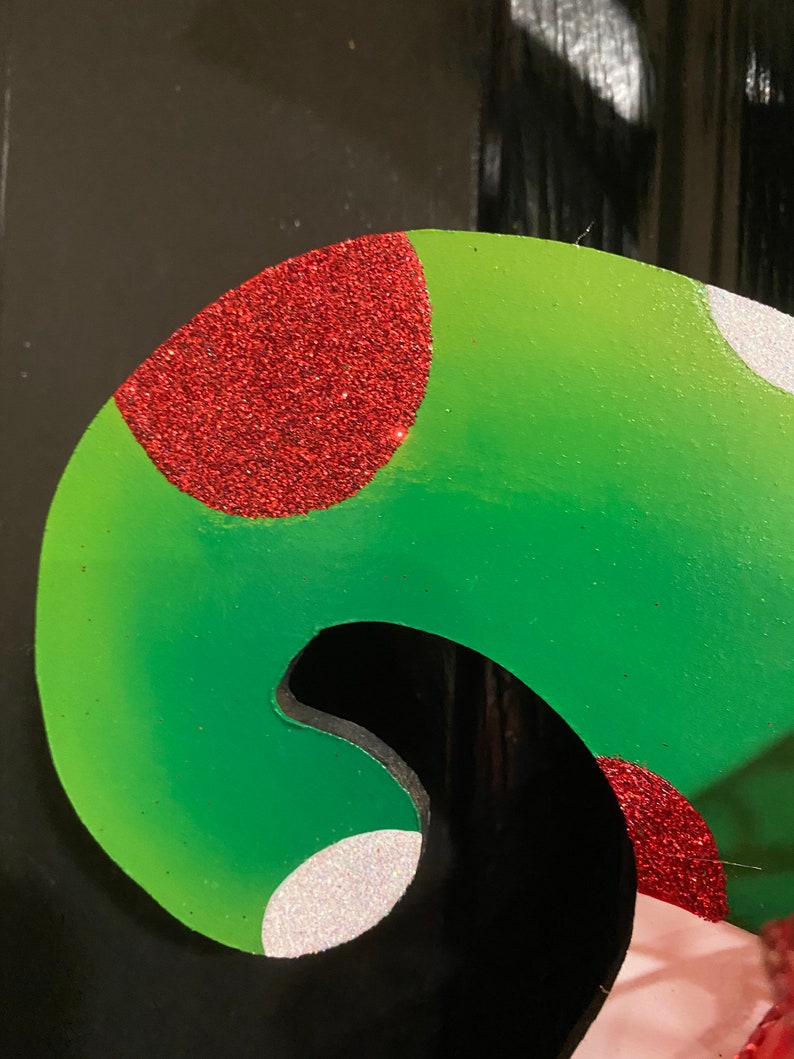 K&ouml;nnte beinhalten: Ein gr&uuml;ner und roter Weihnachtssocken mit wei&szlig;en Punkten. Der Socken ist aus Filz und hat eine glitzernde Oberfl&auml;che.