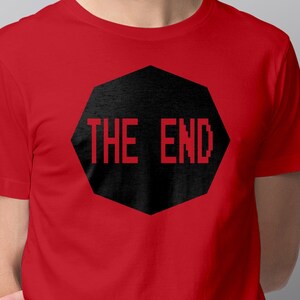 May include: Red t-shirt with a black octagon shape that says "THE END" in white letters.