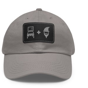 May include: A gray baseball cap with a black patch featuring a pinball machine and a wizard with a beard and a pointed hat. The text on the patch reads "Pinball + Wizard".