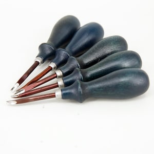 May include: Set of five blue-green handled tools with red metal blades. The tools have a rounded, teardrop-shaped handle and are arranged in a fan shape.
