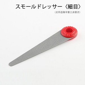 Puede incluir: Una herramienta alargada de color plateado con un mango circular rojo. La herramienta tiene una superficie texturizada y se estrecha hasta un punto redondeado. El mango tiene texto en relieve alrededor de su perímetro. Texto japonés visible en la parte superior de la imagen.