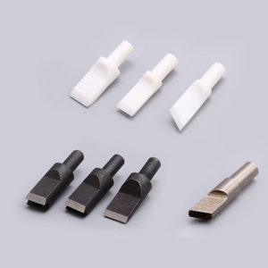 Puede incluir: Conjunto de seis herramientas diferentes para la elaboración de cuero. Tres herramientas de cerámica blanca y tres herramientas de metal negro. Una herramienta es plateada con una punta en forma de diamante.