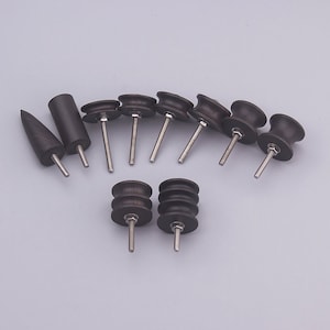 May include: A set of ten black wood sanding tools with threaded metal shafts. The tools are of various shapes and sizes, including round, conical, and cylindrical.