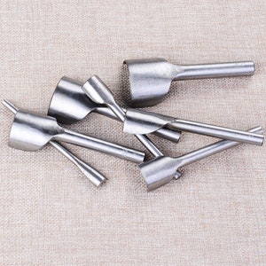 May include: A set of six silver leather hole punches with different sizes. The punches are made of metal and have a handle for easy use.