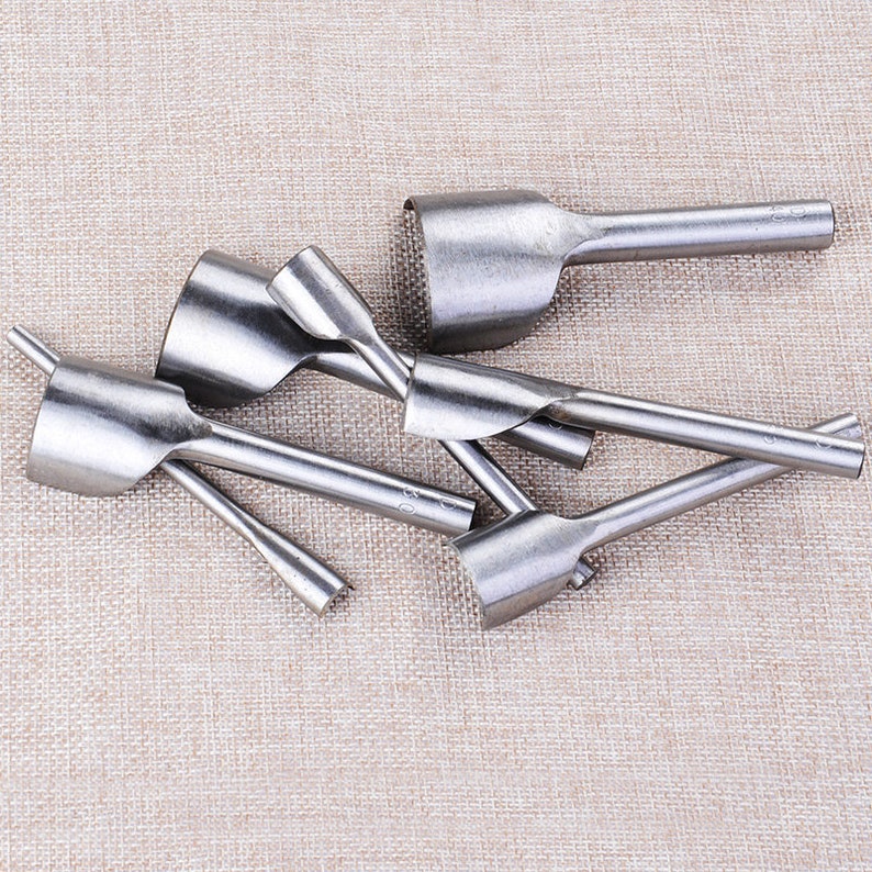 May include: A set of six silver leather hole punches with different sizes. The punches are made of metal and have a handle for easy use.