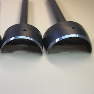 K&ouml;nnte beinhalten: Drei schwarze Leder-Lochstanzeisen aus Metall mit verschiedenen runden L&ouml;chern. Die Werkzeuge haben eine abgerundete, gebogene Form und einen Griff.