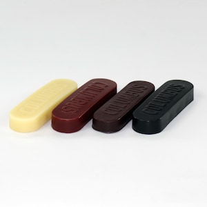 May include: Four shoe polish bars in different colors: white, burgundy, brown, and black. Each bar is labeled "COLUMBUS".