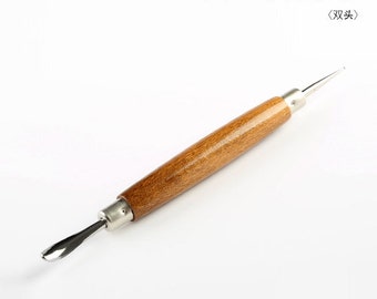 May include: A wooden handled tool with a double-ended metal tip. The tool is called a "Trace Monogram" in Japanese.
