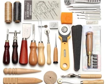 Op de afbeelding: Een set lederbewerkingstools, waaronder priem, naaiwerktuigen, een rolmes, een pons en verschillende naalden. De tools zijn gerangschikt op een witte achtergrond.