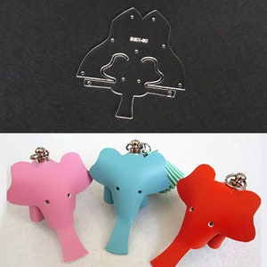 Peut inclure: Trois porte-clés en cuir en forme d'éléphant, un rose, un bleu et un rouge. Chaque porte-clés a un anneau argenté et un petit pompon. Les porte-clés sont en cuir et ont la forme d'éléphants.