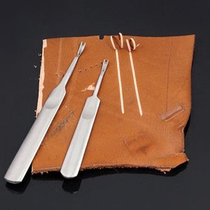 May include: Three silver leather crafting tools on a brown leather surface. The tools are used for stitching leather.