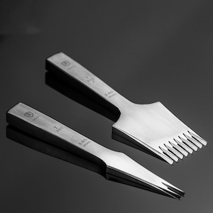 Może przedstawiać: Dwa srebrne narzędzia do dziurkowania skóry z różnymi rozmiarami końcówek. Większe narzędzie ma 7 końcówek i jest oznaczone "7 REV 3,85 mm". Mniejsze narzędzie ma 9 końcówek i jest oznaczone "7 REV 2,45 mm".