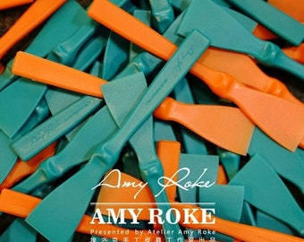 Puede incluir: Un montón de herramientas de plástico de color turquesa y naranja con el texto "Amy Roke" y "Presented by Atelier Amy Roke" en negro. El texto "埃洛克手工皮具工作室出品" está en negro sobre fondo blanco.