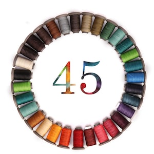 May include: A circle of 45 spools of thread in various colors, arranged in a rainbow pattern. The spools are all the same size and shape, and they are all wound with thread.