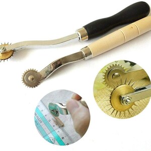 May include: Two sewing tools with wooden handles and metal wheels with sharp points. The wheels are designed to create holes in fabric for sewing.