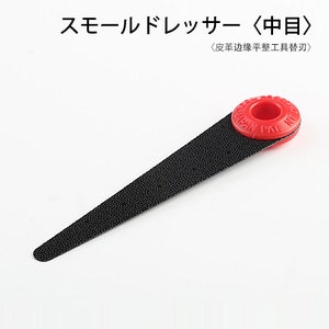Puede incluir: Una lima de metal negra con un mango de plástico rojo. El mango tiene un agujero en el centro y el texto "JAPAN PAL" impreso en él. La lima está etiquetada como "スモールドレッサー〈中目〉〈皮革边缘平整工具替刃〉".
