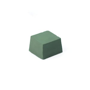 May include: A square block of green polishing compound.