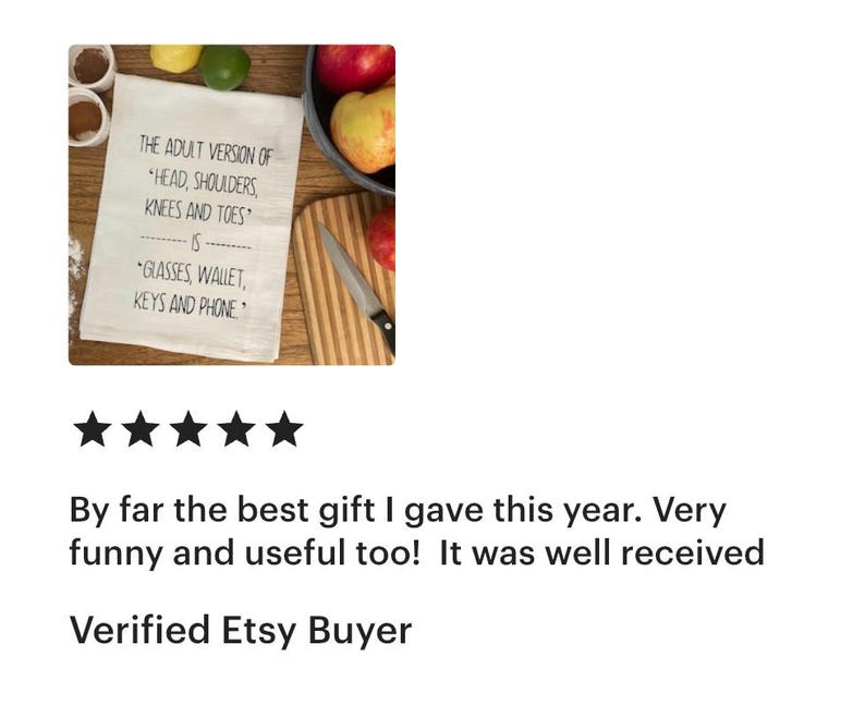 May include: A white rectangular kitchen towel featuring black printed text that reads: The adult version of head, shoulders, knees and toes is glasses, wallet, keys and phone. The towel is displayed alongside fresh fruit and a kitchen knife.