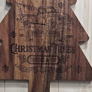 May include: Wooden Christmas tree-shaped sign with engraved text and illustrations. The sign reads "Holly Jolly Farms" and "Farm Fresh Christmas Trees, Choose & Cut" with a vintage truck graphic and snowflake accents.