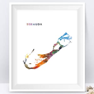 May include: A white framed print featuring a colourful watercolour illustration of the island of Bermuda. The word "BERMUDA" is printed in a colourful font at the top of the print.