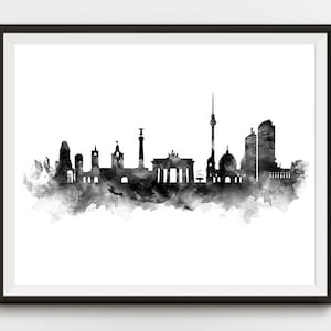 May include: Black and white watercolor painting of the Berlin skyline. The skyline includes the Brandenburg Gate, the Berlin TV Tower, and other iconic buildings.