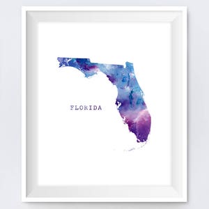 May include: A watercolor painting of the state of Florida in shades of purple and blue. The word "FLORIDA" is written in white text below the state outline.
