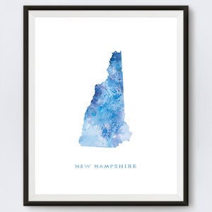 May include: A watercolor painting of the state of New Hampshire in shades of blue. The state's outline is filled with a blue watercolor wash, with white and light blue accents. The words "NEW HAMPSHIRE" are printed in blue below the state.