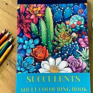 May include: A spiral-bound adult coloring book titled "Succulents" with a vibrant cover illustration of various succulents and flowers in shades of green, blue, orange, and pink. Colored pencils are visible on the left side.