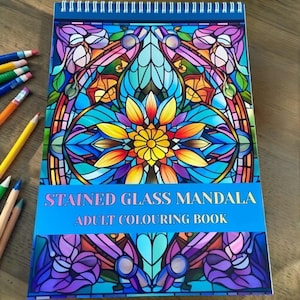 May include: A spiral-bound adult colouring book with a stained glass mandala design. The cover features a vibrant, colourful floral pattern in shades of blue, purple, yellow, and orange. The text "STAINED GLASS MANDALA ADULT COLOURING BOOK" is displayed on a blue banner.