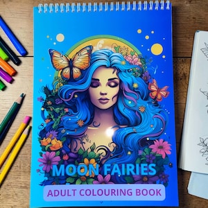 May include: A spiral-bound adult coloring book with a blue cover featuring a woman with blue hair, butterflies, and flowers. The title "MOON FAIRIES" and "ADULT COLOURING BOOK" are printed on the cover. Colored pencils are visible on the left.