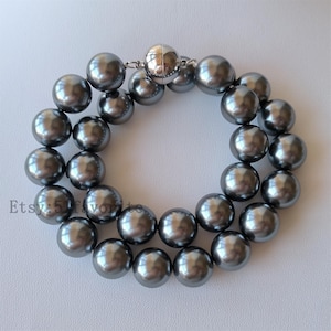 Peut inclure: Un collier à double rang de grandes perles rondes en imitation de perles grises avec un fermoir magnétique.