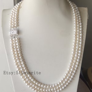 May include: A three-strand pearl necklace with a silver clasp. The necklace is made of white pearls and is approximately 46 cm long. Etsy: 51favorite