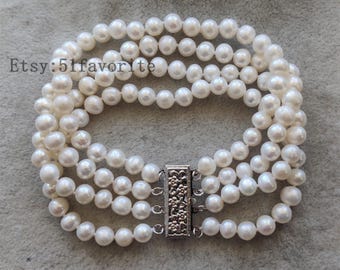 May include: A white pearl bracelet with a silver clasp. The bracelet is made of four strands of pearls and has a total of 40 pearls.