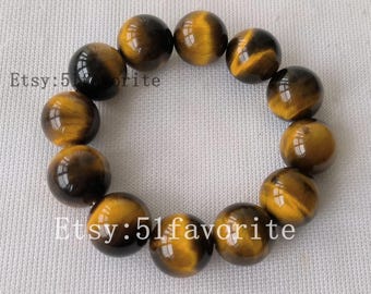 Puede incluir: Un brazalete con cuentas de ojo de tigre pulidas. Las cuentas exhiben una mezcla de amarillo dorado y marrón oscuro, dispuestas en forma circular. El texto "Etsy: 51favorite" es visible.