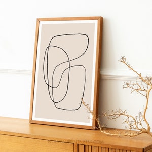 May include: A framed abstract art print with a beige background and black line drawings of overlapping circles and ovals.