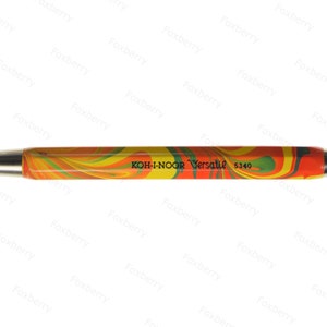 K&ouml;nnte beinhalten: Ein gelber, orangefarbener und gr&uuml;ner Bleistift mit silberner Spitze und einem schwarzen Etikett mit der Aufschrift "KOH-I-NOOR Versatil 5340".