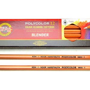 Op de afbeelding: Twee bruine mengpotloden met witte punten en gouden accenten. De potloden zijn geëtiketteerd met "KOH-I-NOOR HARDTMUTH POLYCOLOR 3800/0". De potloden zijn verpakt in een rood-zwarte doos met het label "POLYCOLOR 12 COLOUR BLENDING/SOFTENING BLENDER".