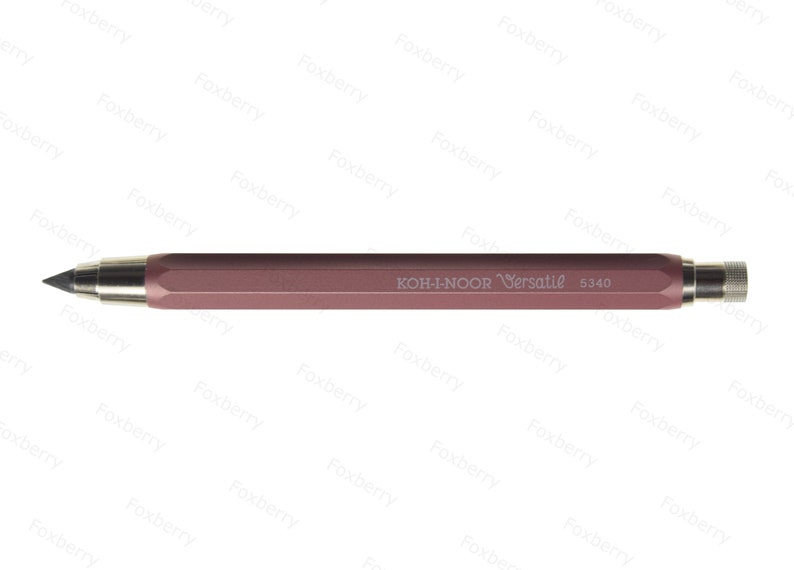 K&ouml;nnte beinhalten: Ein ros&eacute;goldener mechanischer Bleistift mit einer silbernen Metallspitze und einem Radiergummi. Der Bleistift ist mit "KOH-I-NOOR Versatil 5340" beschriftet.