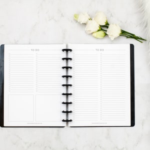 May include: A black and white to-do list planner with a black coil binding. The planner has two pages with lines and checkboxes for writing down tasks. The text "TO DO" is printed at the top of each page.