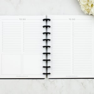 May include: A white planner with black rings and the text "TO DO" at the top of each page. The planner has a blank space for notes and a checklist.