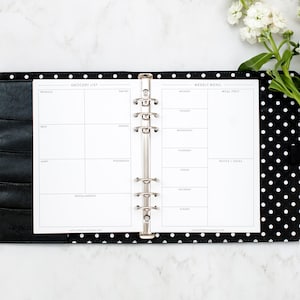Pu&ograve; includere: Un planner a pois neri e bianchi con una pagina bianca aperta su una lista della spesa e un menu settimanale. La lista della spesa &egrave; divisa in sezioni per prodotti, carne, latticini, surgelati, prodotti per la casa e vari. Il menu settimanale ha sezioni per dal luned&igrave; alla domenica, preparazione dei pasti e note e idee.