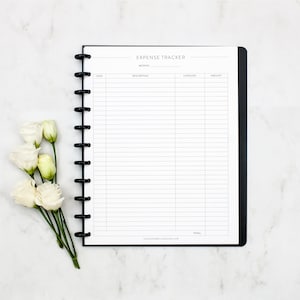 May include: A black and white expense tracker with a black spiral binding. The tracker has columns for date, description, category, and amount. The words "EXPENSE TRACKER" are at the top of the page.