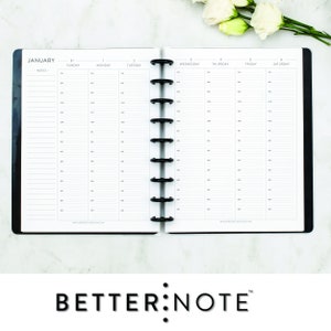 May include: A black and white planner with a white background and black text. The planner is open to the month of January and shows the days of the week. The planner has a black binding with silver rings. The planner is on a white marble surface.