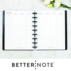 May include: A white monthly planner with a black cover and a black coil binding. The planner is open to January and has the words "JANUARY" and "NOTES" printed at the top. The days of the week are listed across the top of the planner, with the numbers 31, 1, 2, 3, 4, 5, and 6 printed below each day.