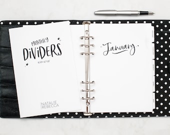 Puede incluir: Una agenda negra y blanca con un encuadernador plateado. La agenda tiene una página blanca con el texto "January" escrito en cursiva negra. La agenda también tiene una página blanca con el texto "Monthly Dividers" escrito en negro. La agenda está sobre una superficie de lunares negros y blancos.