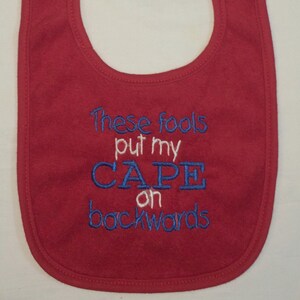 These fools put my cape on backwards embroidered bib